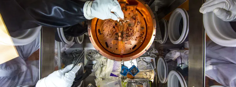 Reseachers work on the MAJORANA experiemnt at SURF inside a clean box with gloves.