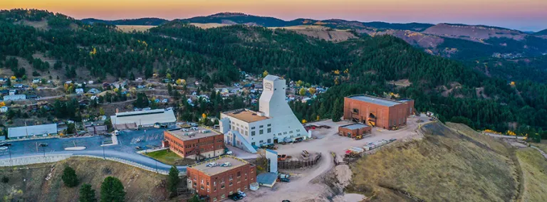 A shot from the air of SURF showing the Yates headframe and surrounding Black Hills during a sunrise. 