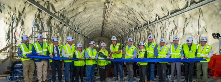 A line of poeple assist in the ribbon cutting to mark the completion of the three-year excavation of the caverns for the Deep Underground Neutrino Experiment 