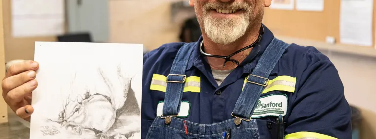 Dan James holds a sketch of a local chipmunk. 