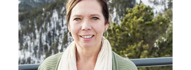 Person in front of a snowy wooded landscape