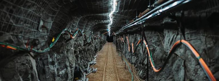 an underground drift at SURF is lit by a single string of lights on the back of the drift