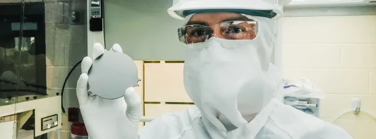 Sam Meijer, staff scientist at Los Alamos National Laboratory, holds a tantalum plate in a cleanroom on the 4850 Level of Sanford Underground Research Facility, where a new experiment is searching for  the decay of nature’s rarest isotope. Photo by Erin Lorraine Broberg 