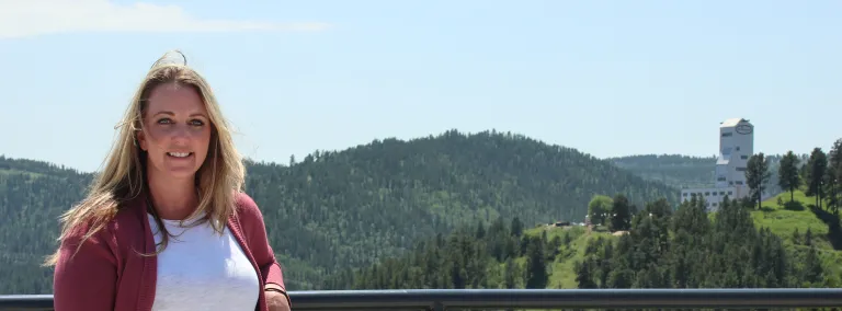 Julie Ewing, Sanford Lab's new Health and Safety Superintendent, stands in front of Grizzly Gulch and the Ross Headframe. 