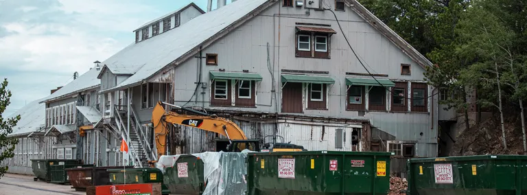 Large building in yard with dumpsters in front