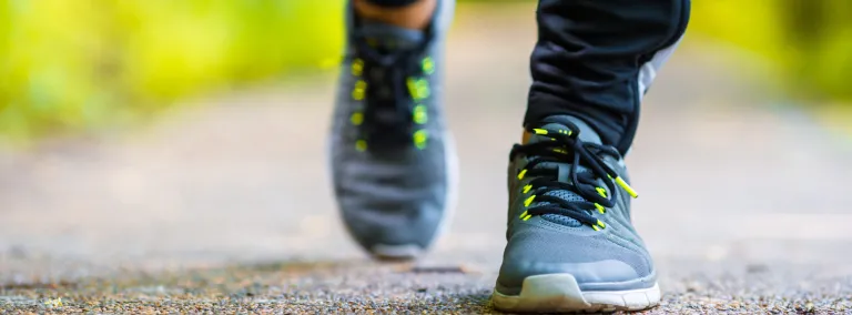 closeup of two feet in tennis shoes running on a path