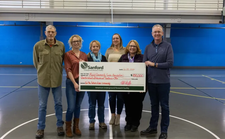 Members of the Lead Community Center Foundation accepted a $100,000 check for the new community center--they are standing inside the Handley Center gym. 