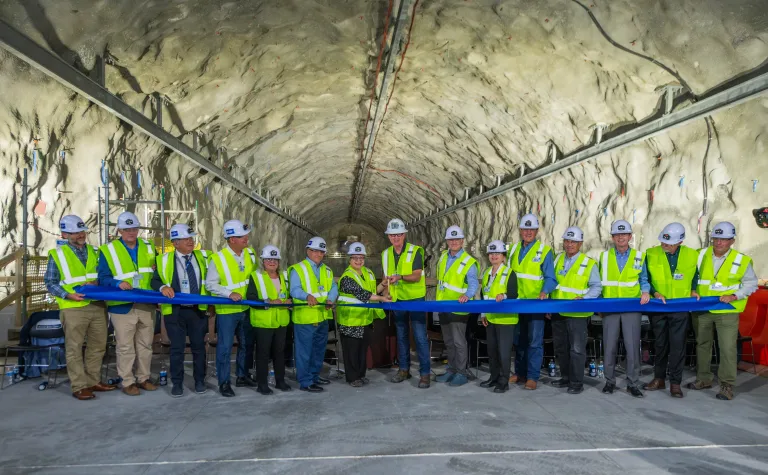 A line of poeple assist in the ribbon cutting to mark the completion of the three-year excavation of the caverns for the Deep Underground Neutrino Experiment 