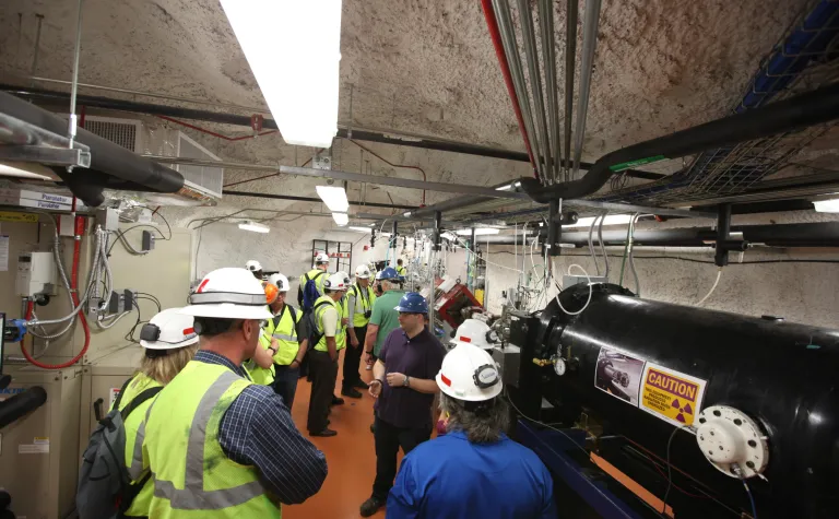 A group of people learn about the CAPSAR experiment.