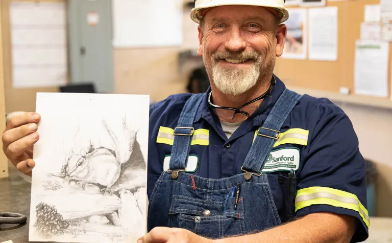 Dan James holds a sketch of a local chipmunk. 