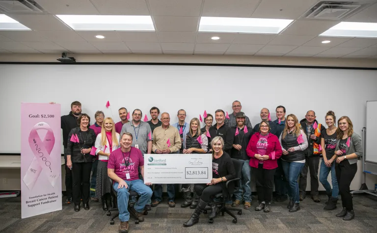 staff dressed in pink during a check presentation