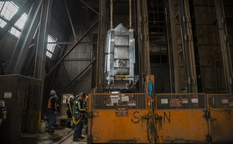 The LZ detector hangs suspended beneath the Yates Cage, with workers to the left.