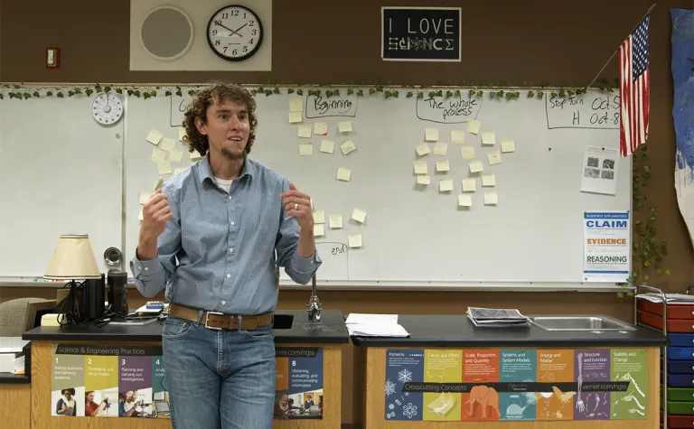 teacher stands at the front of a classroom 