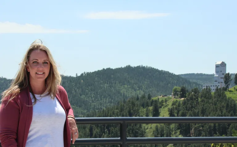 Julie Ewing, Sanford Lab's new Health and Safety Superintendent, stands in front of Grizzly Gulch and the Ross Headframe. 