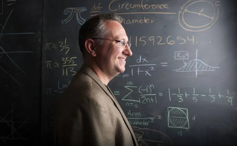 Kowalski stands in front of a blackboard