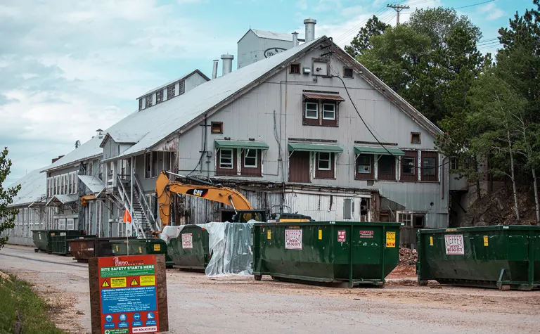 Large building in yard with dumpsters in front