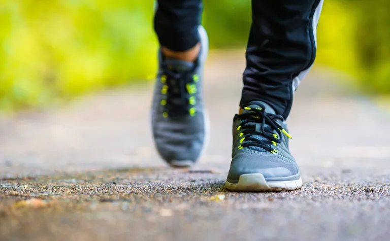 closeup of two feet in tennis shoes running on a path