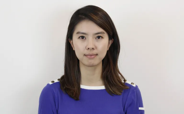 headshot of a person standing against a blank wall