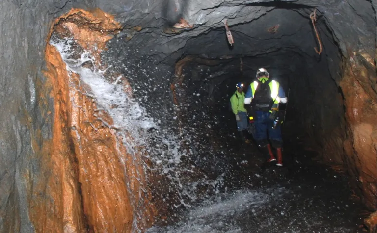 Excess water spills out of borehole in underground drift