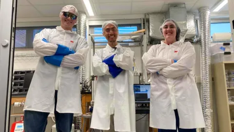 Students in lab coats getting ready to conduct science research