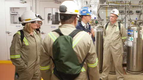 people in protective clothing in lab