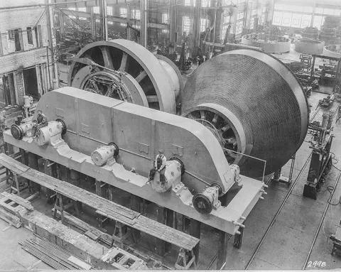 The fully assembled Ross Hoists a black and white photo with workers sitting on the hoists 