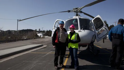 Tom Regan poses in front of a helicopter